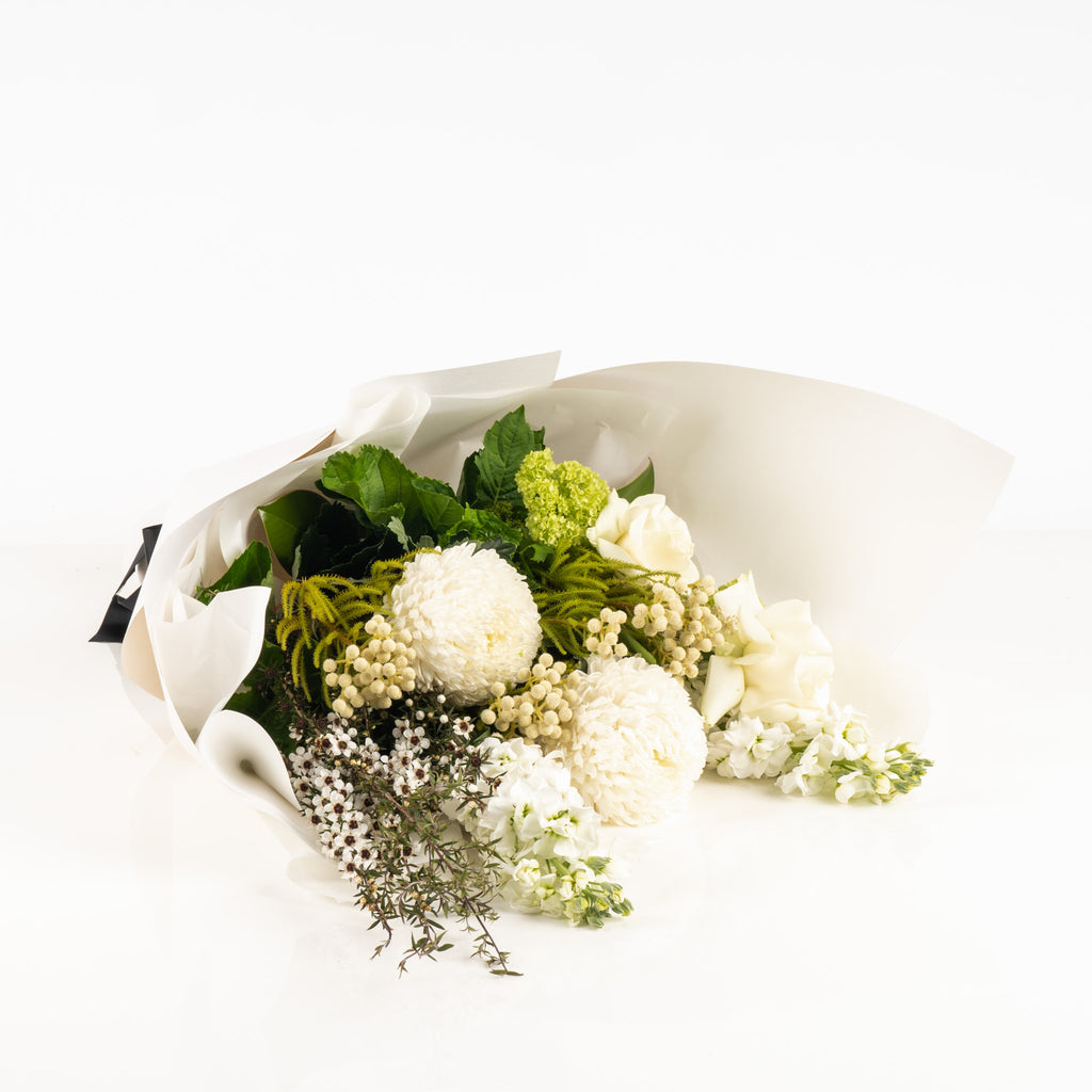 Fresh Whites n Greens Flower Subscription by Wild Poppies showing a lush bouquet of white chrysanthemums, roses, and green foliage laid flat.