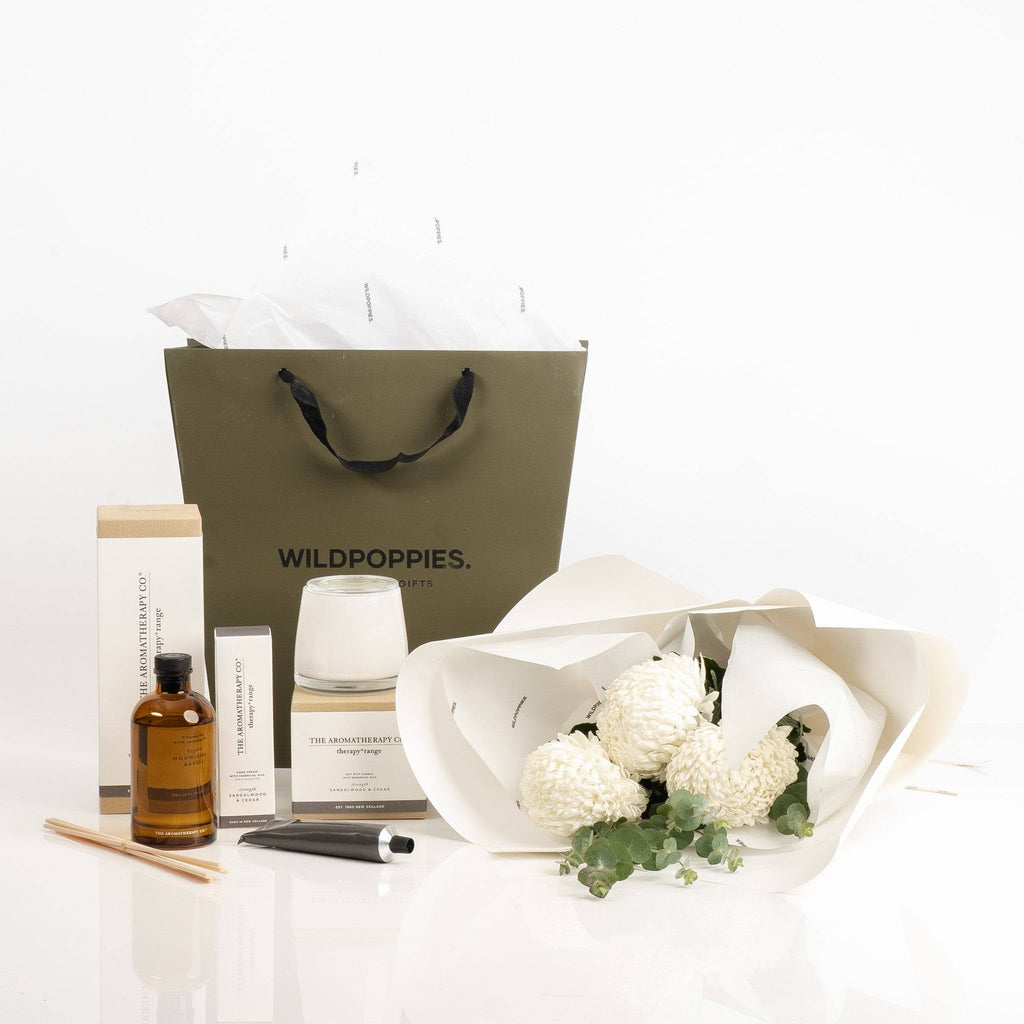 White Chrysanthemum & The Aromatherapy Co. Relaxation Gift Set featuring fresh white chrysanthemums, sandalwood & cedar aromatherapy products, and a Wild Poppies gift bag. Ideal for calming and elegant gift giving.