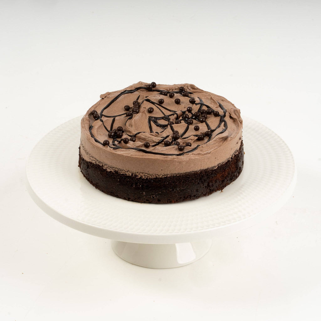 Chocolate cake on a white stand with a white background